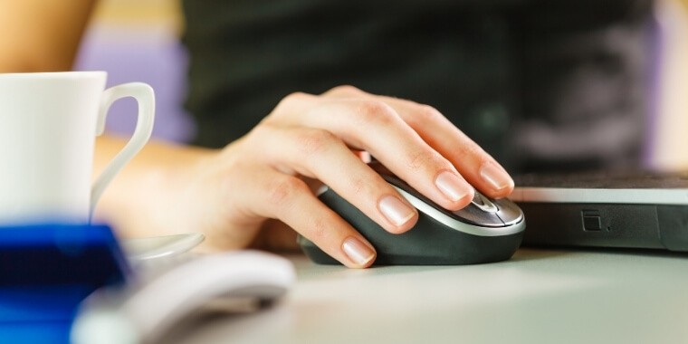 Woman holding a mouse and truong to connect wireless mouse to different receiver