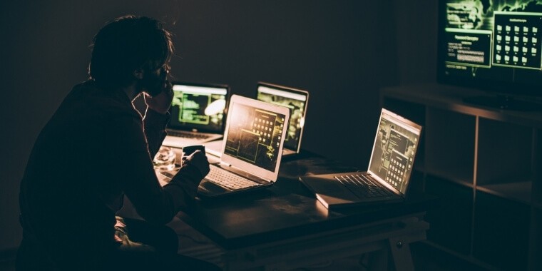 A man checking the backspace functionality on multiple computers