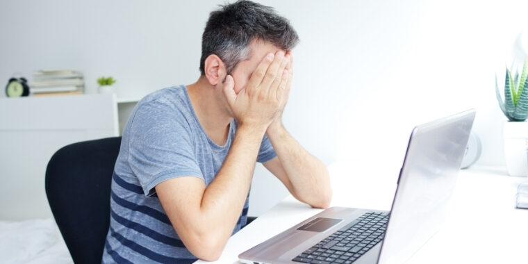 A man sitting worried in front of his computer because his mouse cursor changed to verical line and he doesn't know how to fix it