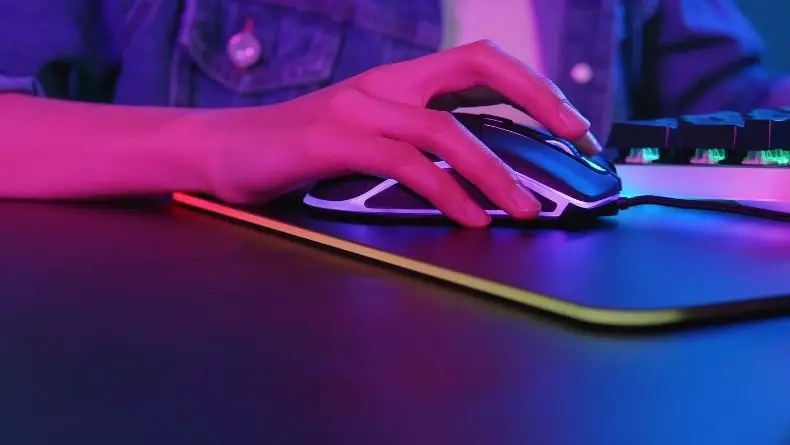 a kid playing computer games and using his mouse on professional mouse pad